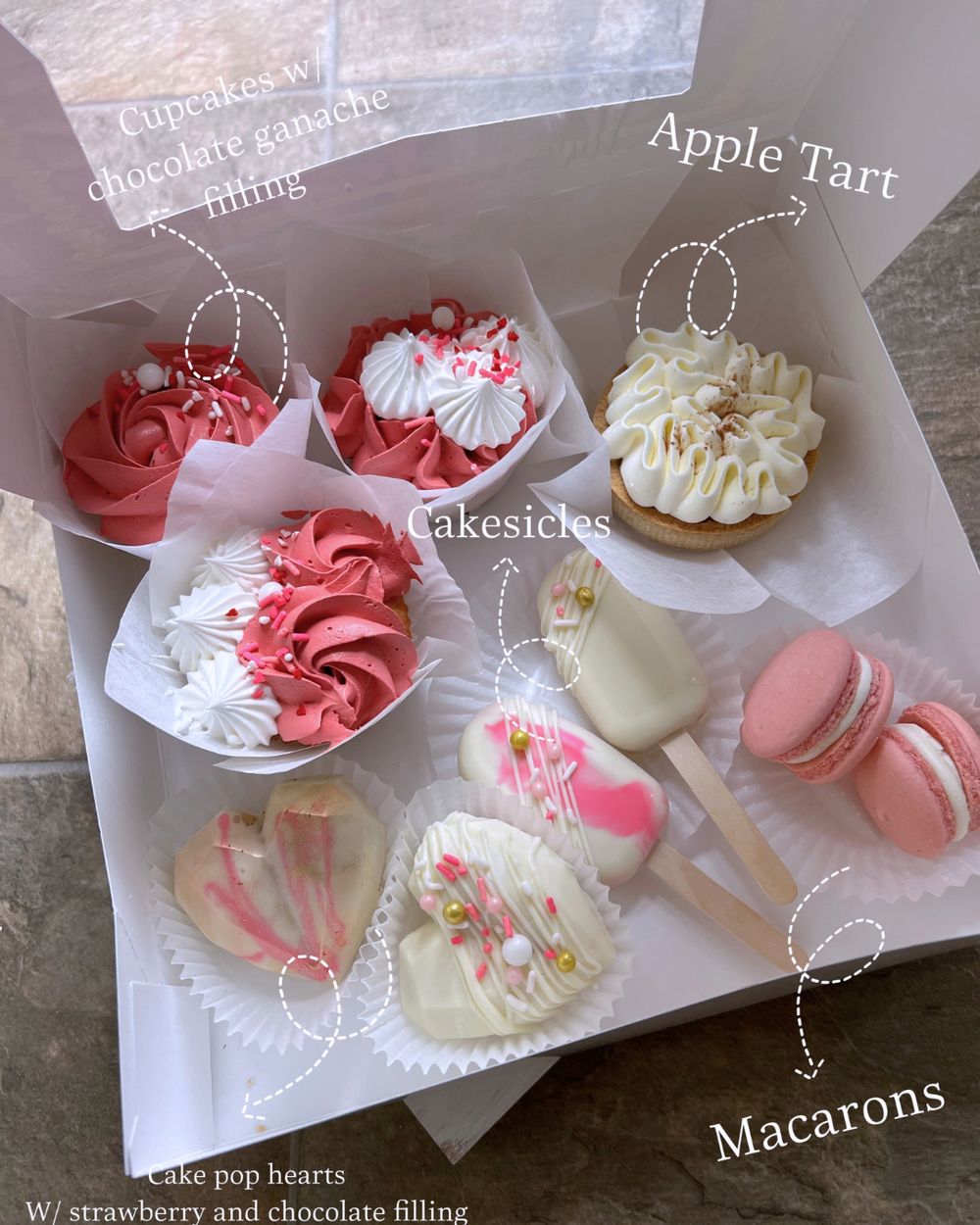 Sampler box with cupcakes, apple tart, cakesicles, macarons and heart cake pops
