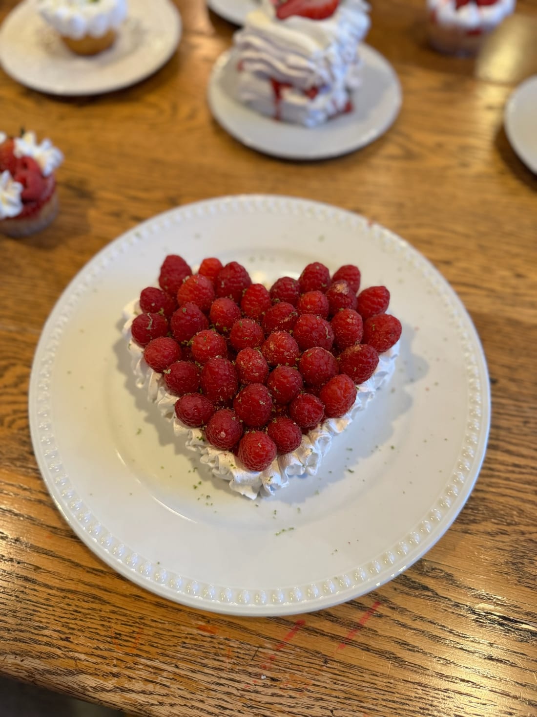 Heart-shaped cake covered in fresh raspberries